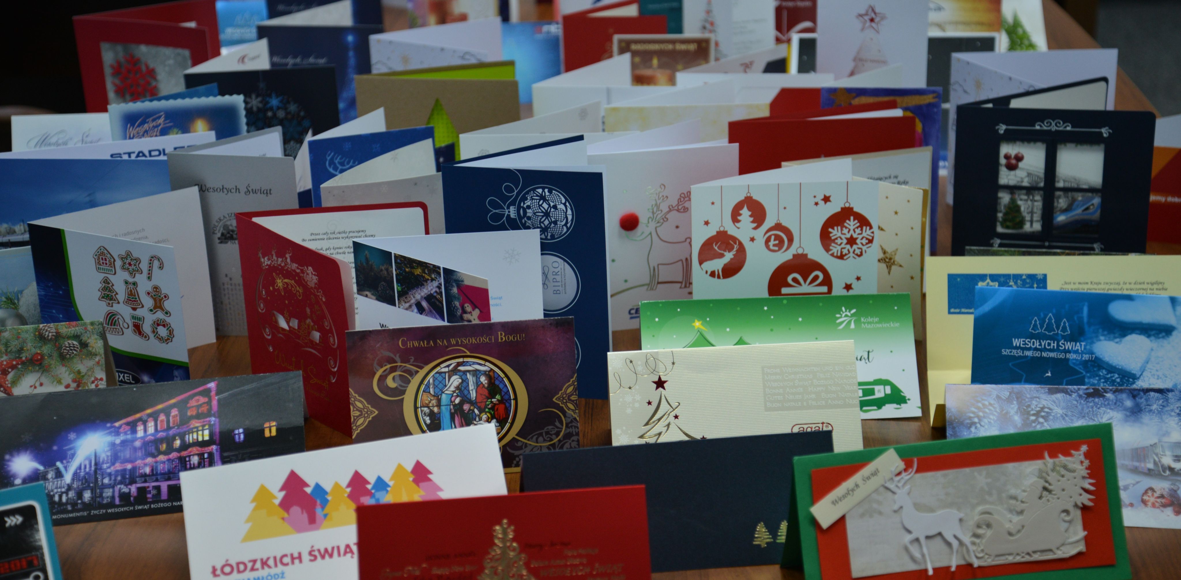 fotografia przedstawia kilkanaście kartek bożonarodzeniowych ustawionych obok siebie